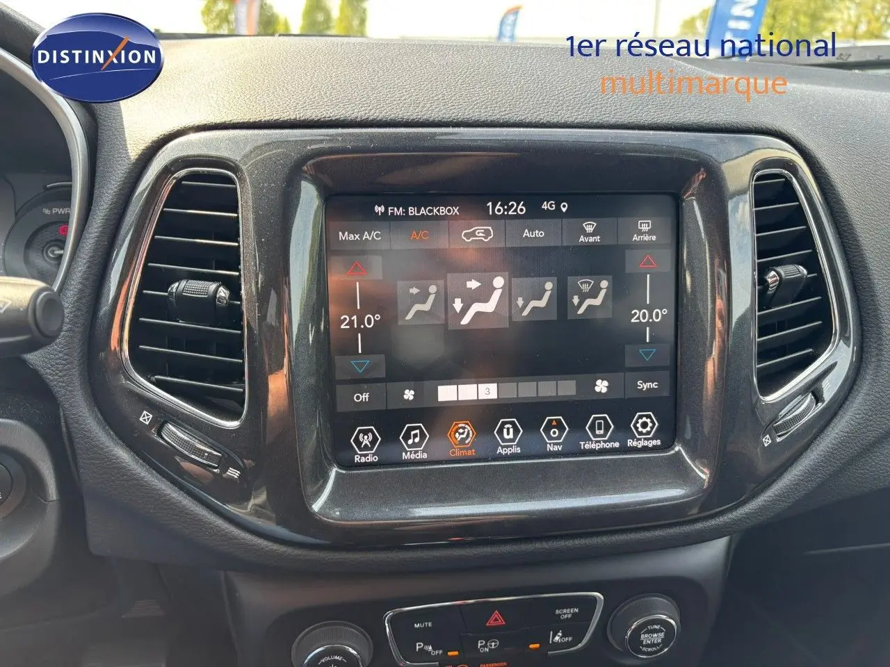 Vue rapprochée de l'écran tactile central du tableau de bord du Jeep Compass blanc, affichant les réglages de climatisation.