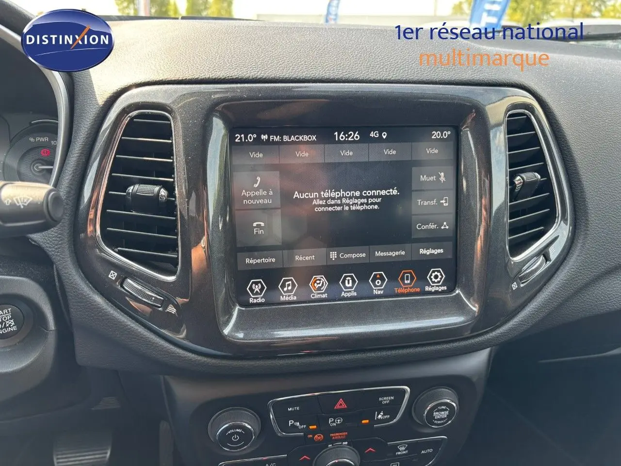 Vue rapprochée de la console centrale du Jeep Compass 2021, écran tactile allumé avec interface multimédia visible.