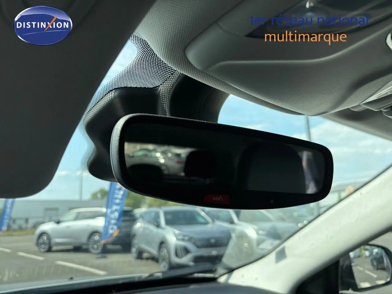 Vue intérieure centrée sur le rétroviseur intérieur d’un Jeep Compass blanc, avec reflet du pare-brise et extérieur flou.