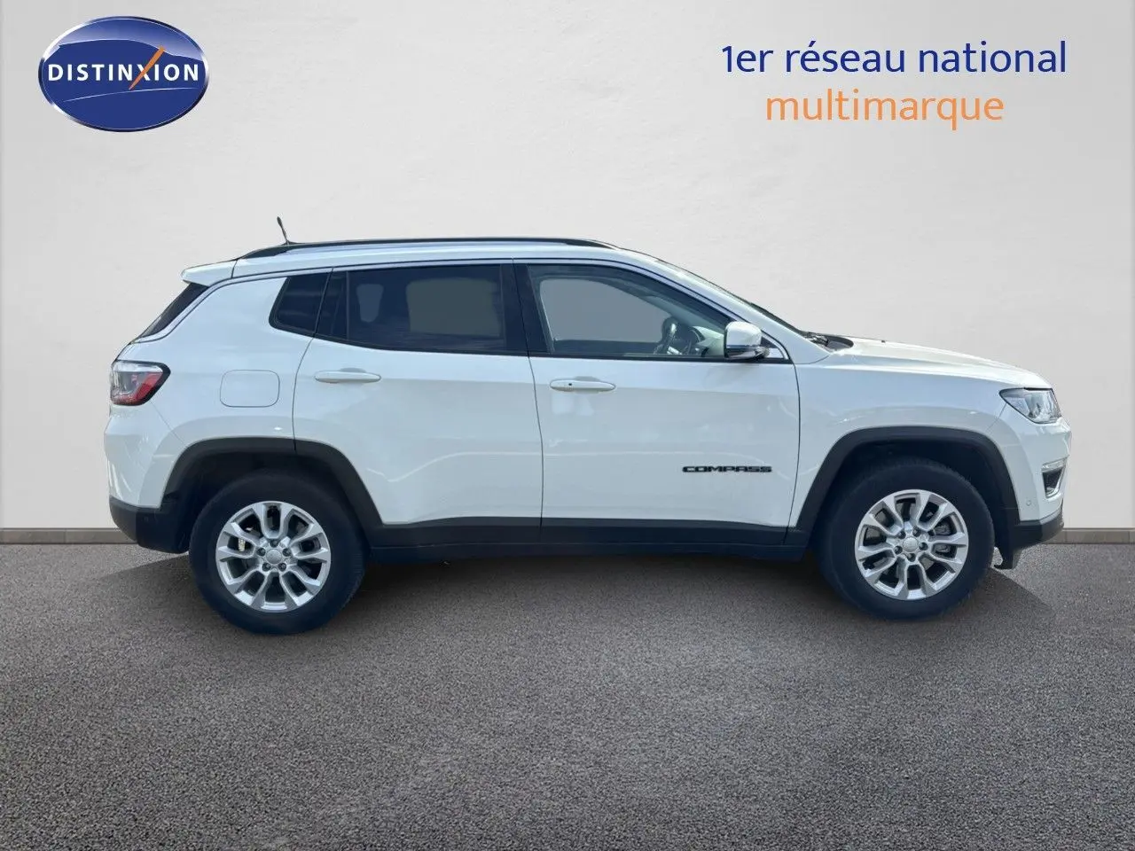 Vue latérale droite d'un Jeep Compass blanc 2021 hybride rechargeable avec jantes alliage et vitres teintées.