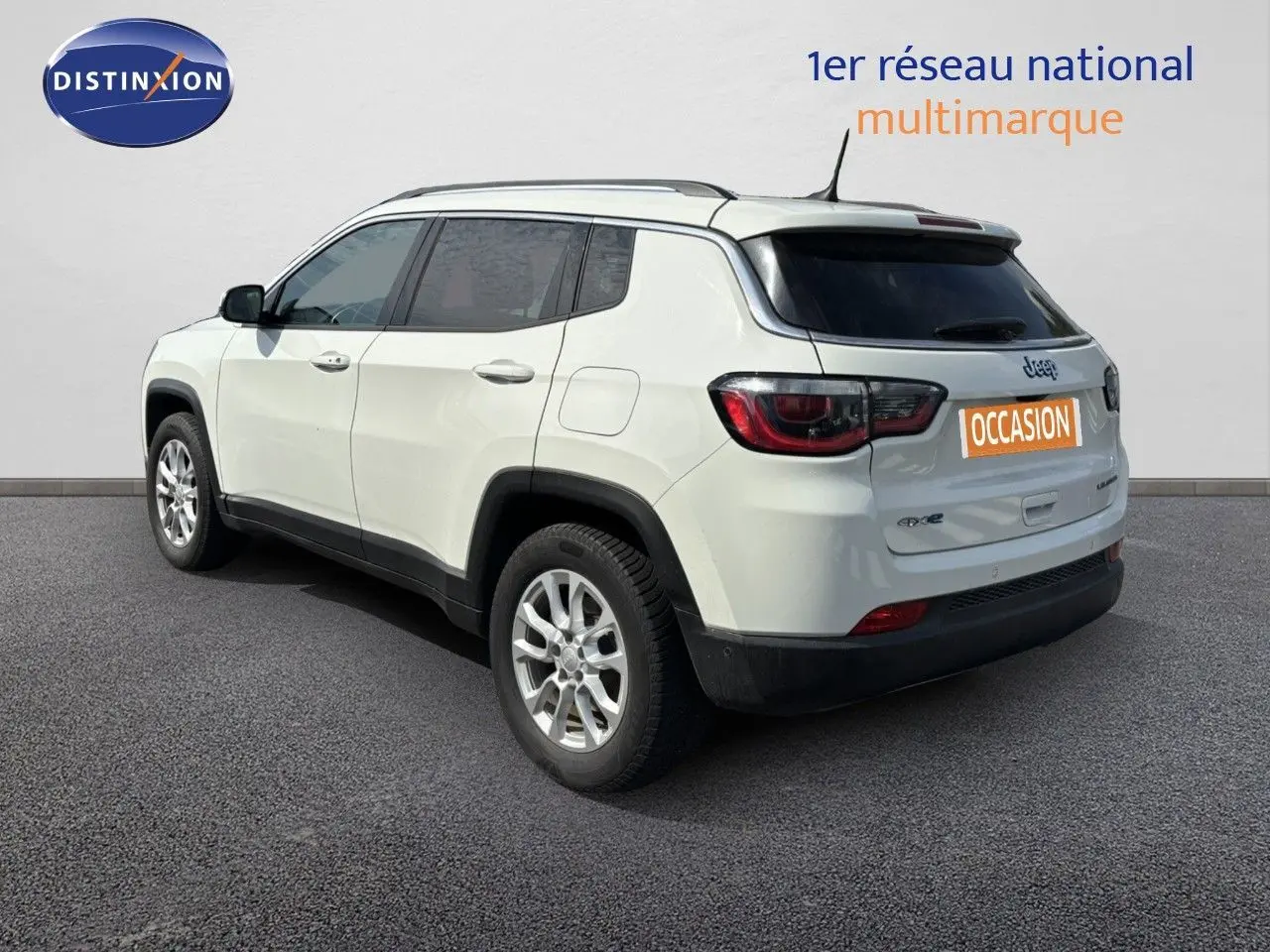 Jeep Compass blanc vue 3/4 arrière droit, SUV hybride rechargeable avec jantes alliage et vitres teintées.