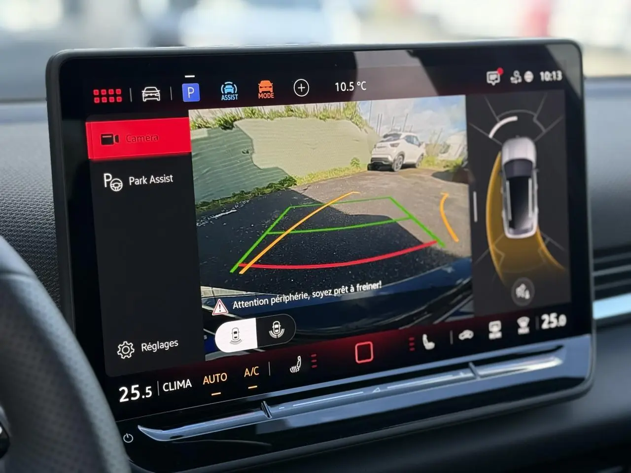 Écran tactile intérieur affichant la caméra de recul et l'assistance au stationnement du Volkswagen T-Roc 2026.