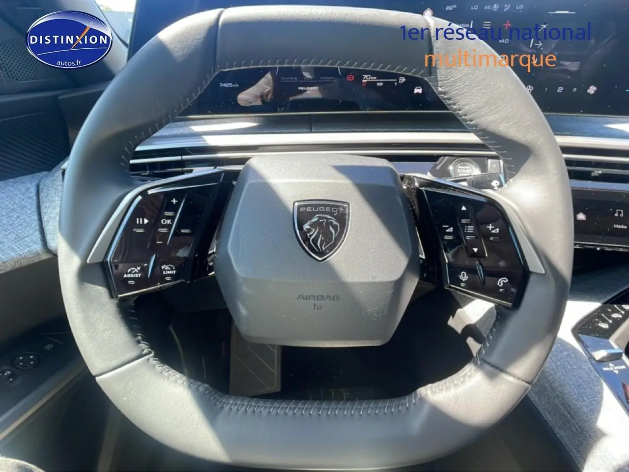 Vue rapprochée du volant cuir gris du Peugeot 3008 1.2 hybrid 145 allure e-dcs6 avec commandes multifonctions.