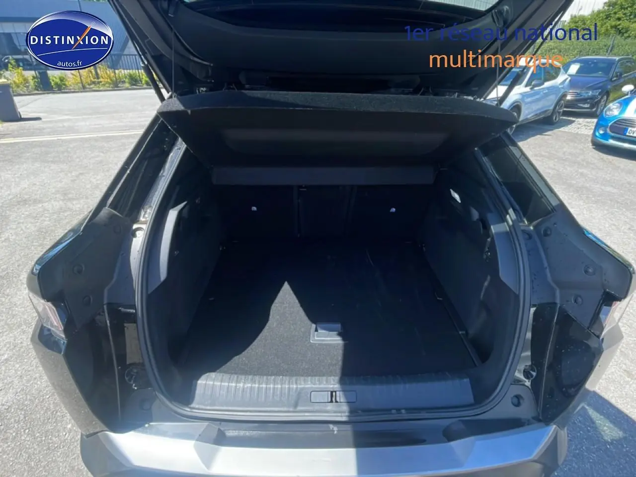 Coffre ouvert vu de l'arrière d'un Peugeot 3008 noir 2025, avec hayon relevé et espace de chargement vide.