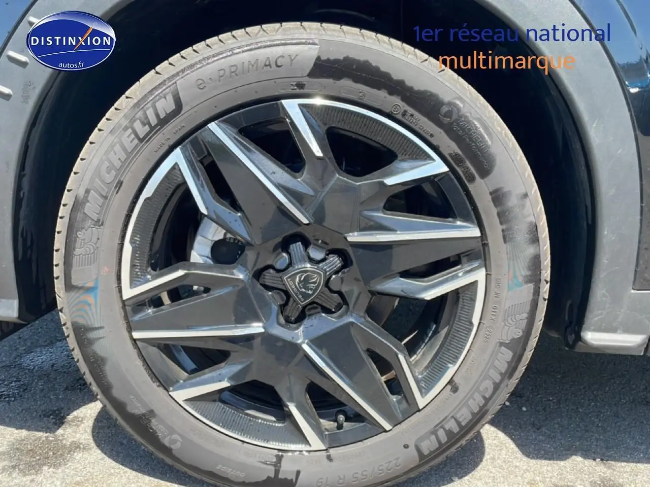 Gros plan sur la roue avant gauche noire du Peugeot 3008 1.2 hybrid 145 allure e-dcs6 avec jante alu distinctive.