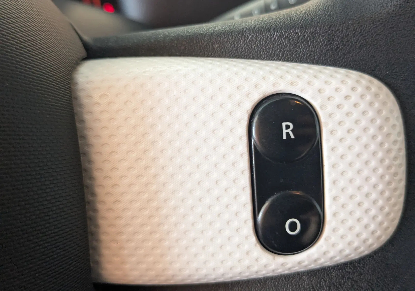 Gros plan sur les boutons de réglage des rétroviseurs intérieurs d’une Renault Twingo III noire, version 2019.