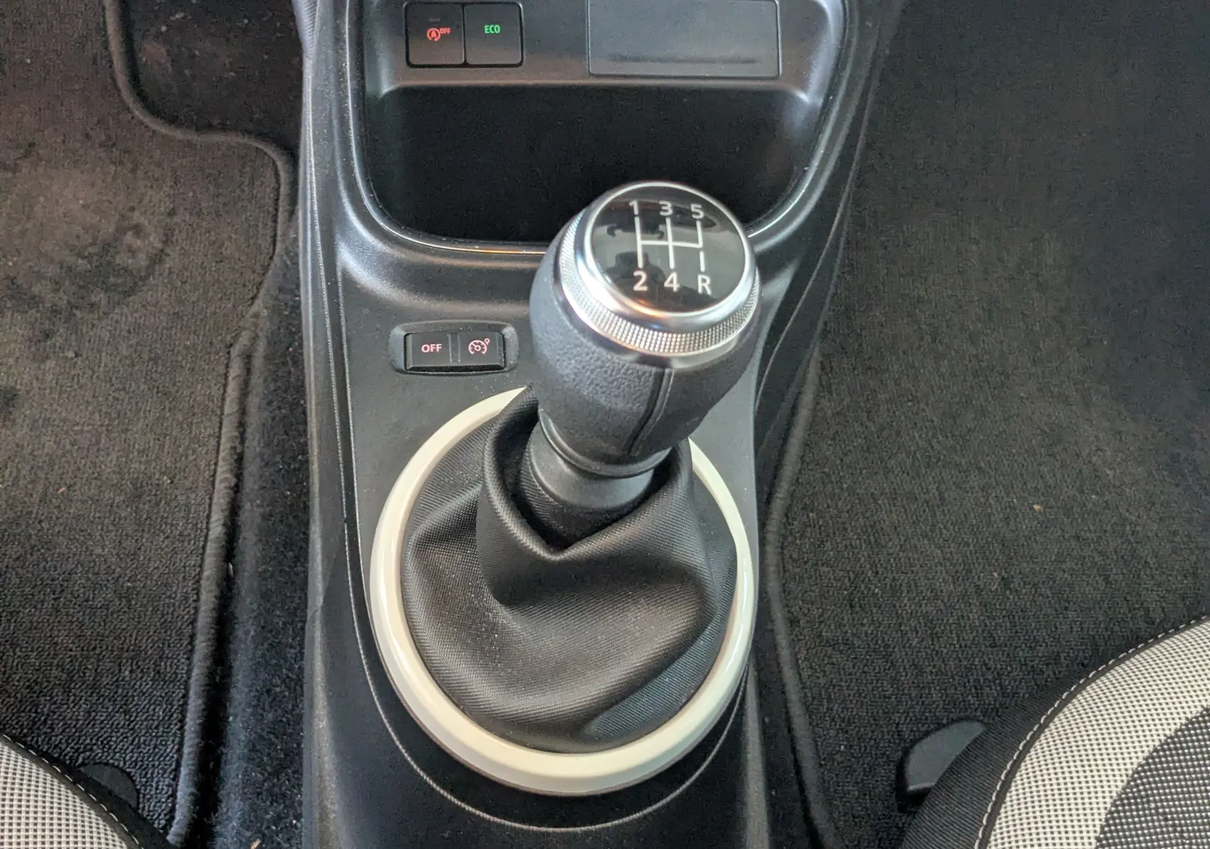 Gros plan sur le levier de vitesses manuel noir de la Renault Twingo III 2019, entouré d’un anneau clair dans l’habitacle.