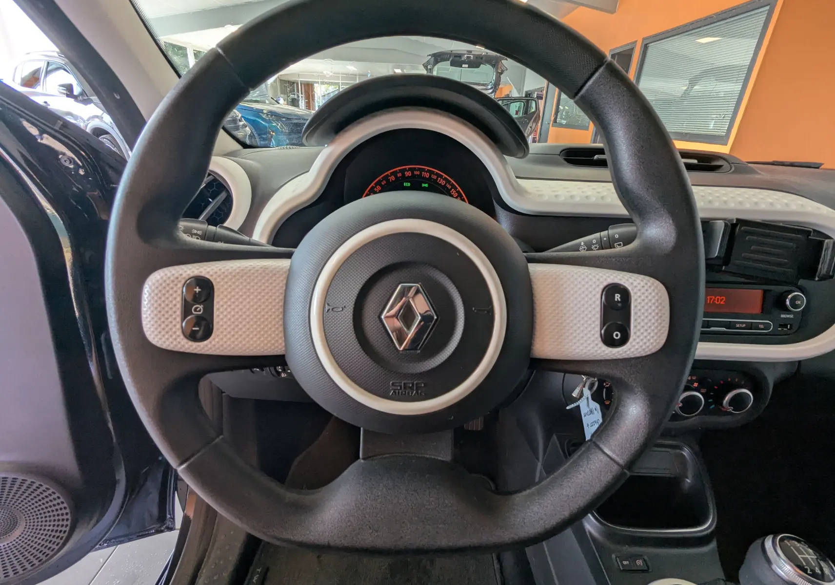 Vue rapprochée du volant noir et beige de la Renault Twingo III 2019, avec tableau de bord et commandes visibles.