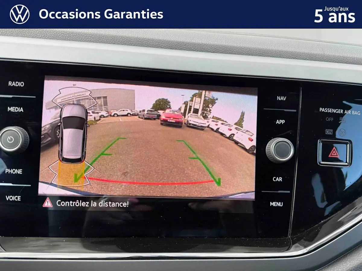 Écran tactile de la caméra de recul du Volkswagen Polo 2025, affichant l'arrière avec lignes de guidage vertes et rouges.