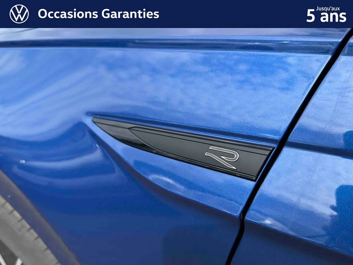Détail de l'aile avant gauche bleu métallisé avec logo "R" noir sur Volkswagen Polo 2025.