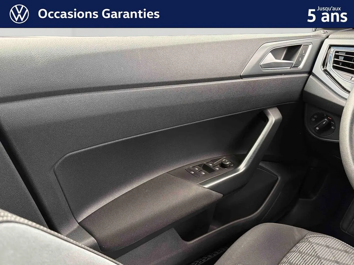 Vue intérieure côté passager avant de la Volkswagen Polo 2025 avec garniture noire et commandes des vitres intégrées.