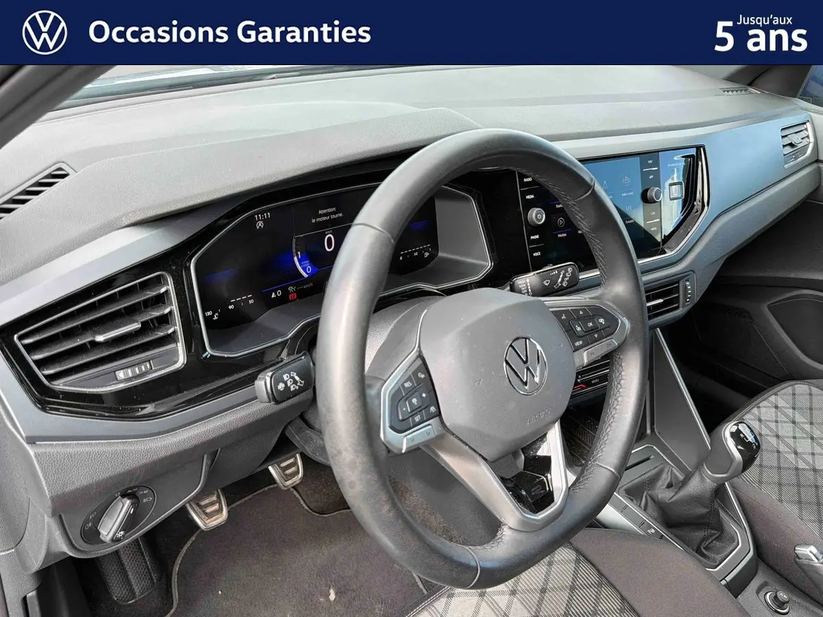 Vue intérieure du poste de conduite de la Volkswagen Polo 2025, volant cuir multifonctions et tableau de bord digital.