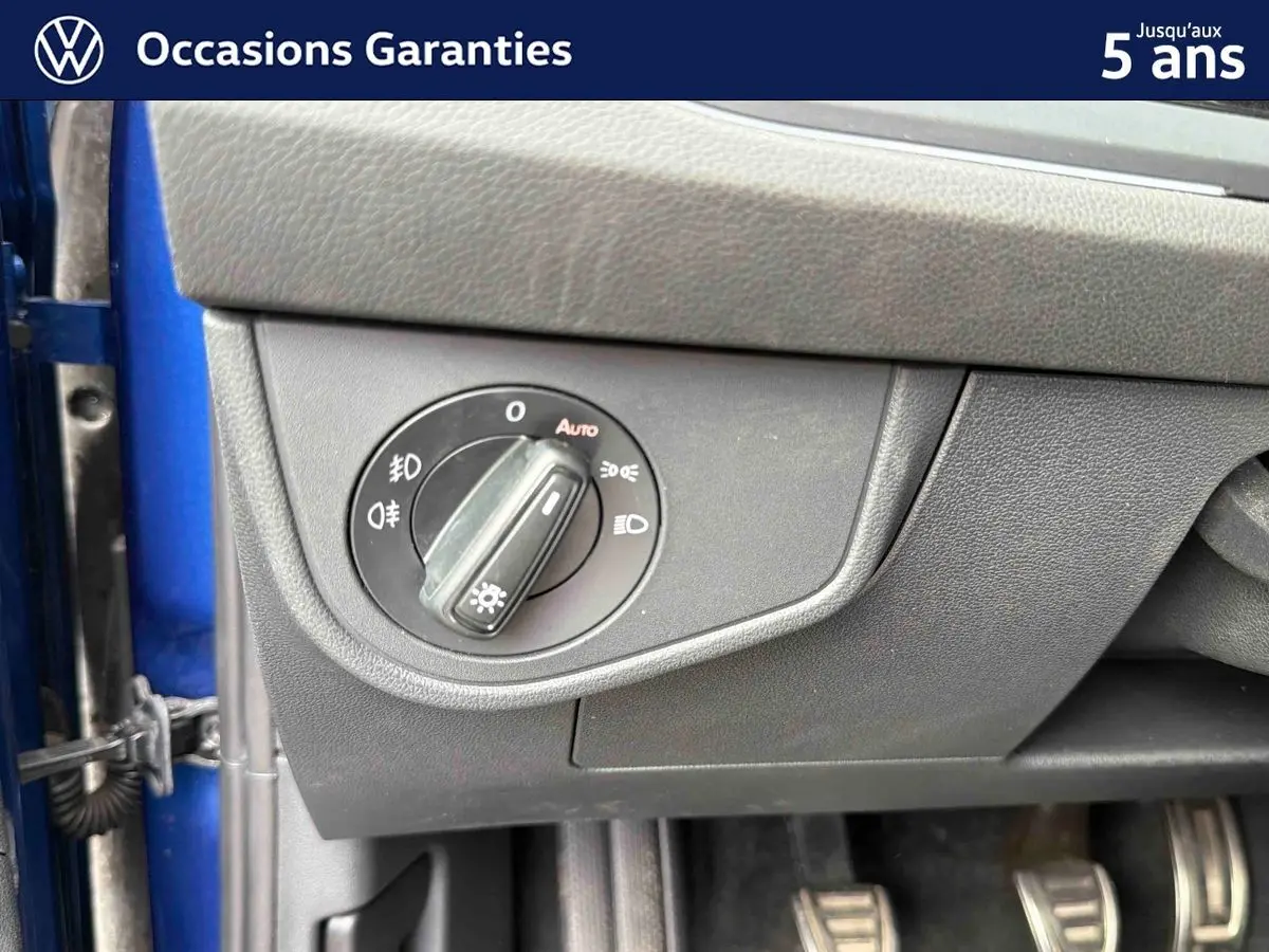 Détail du bouton de commande des phares sur le tableau de bord côté conducteur d’une Volkswagen Polo bleue 2025.
