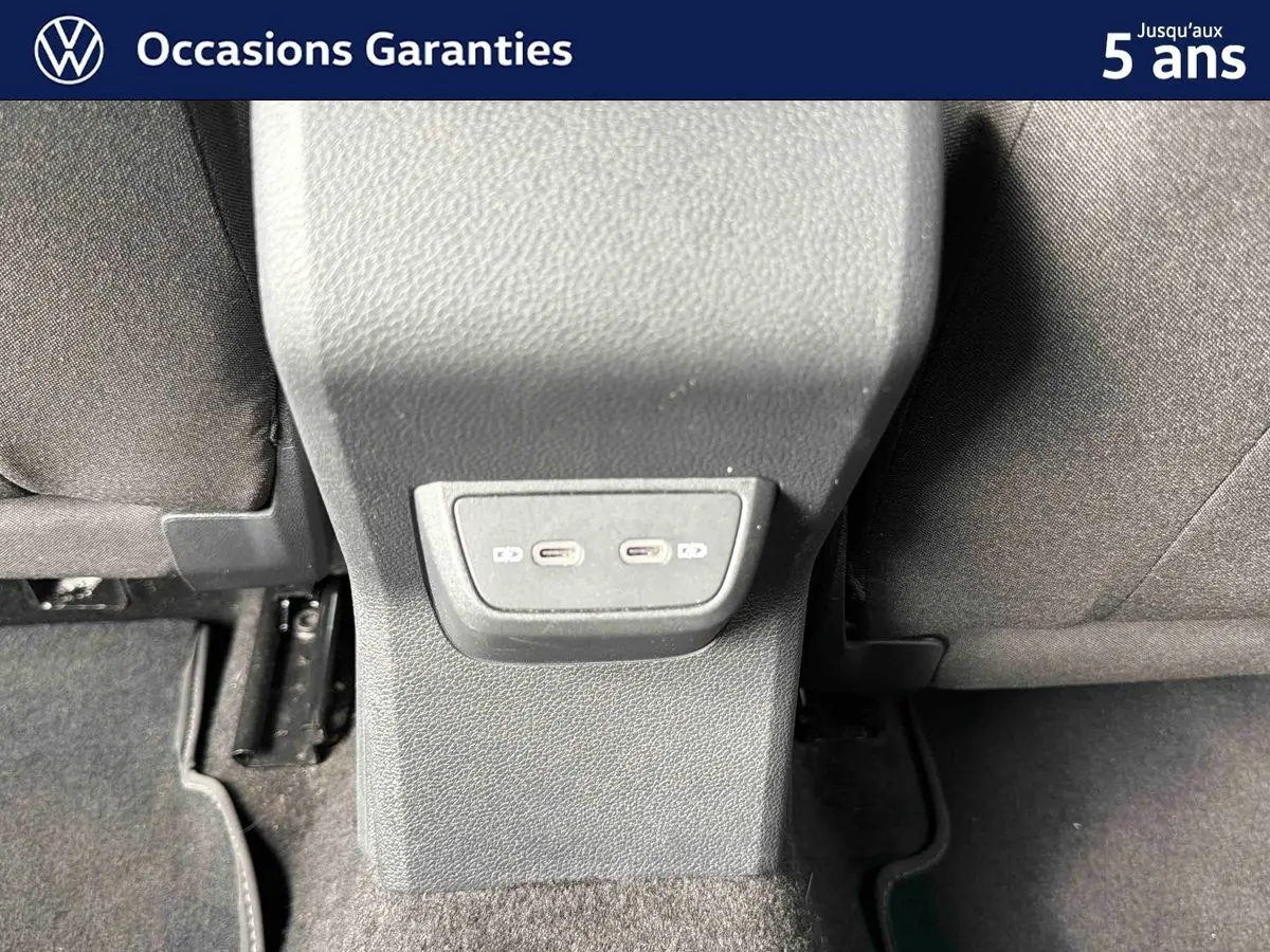 Vue rapprochée des ports USB-C situés à l'arrière de la console centrale entre les sièges arrière d'une Volkswagen Polo bleue.