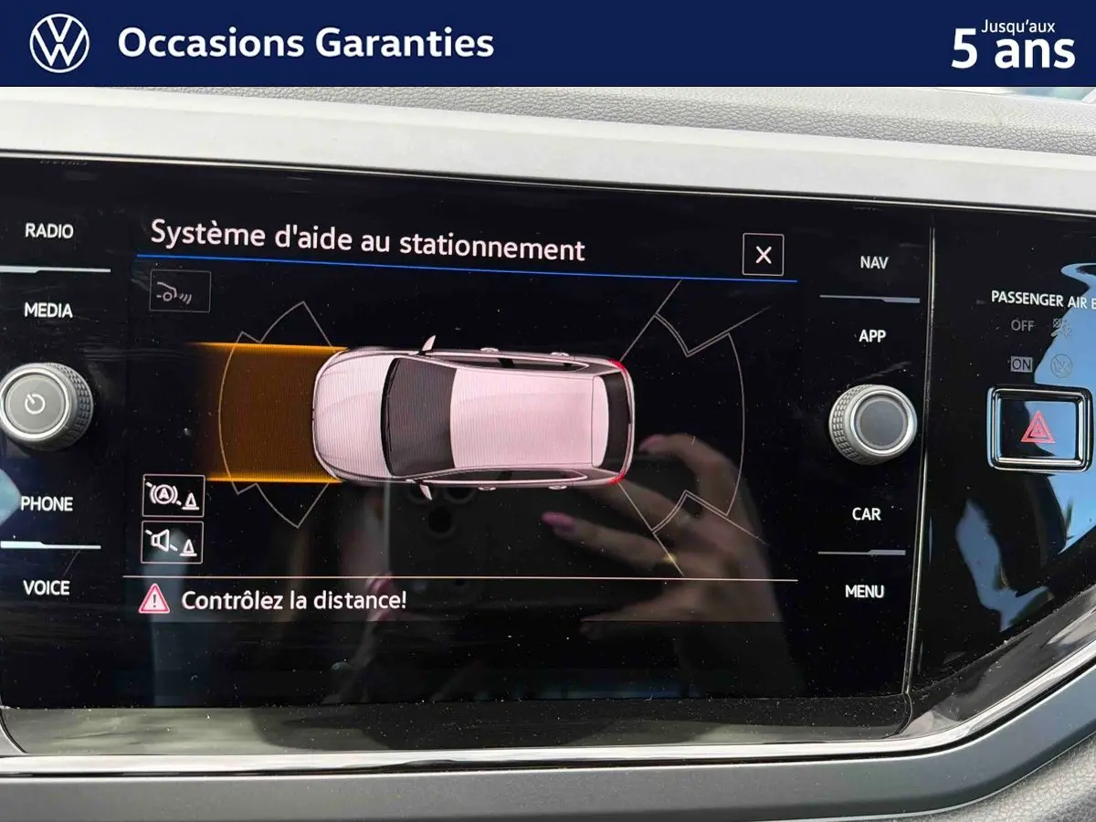 Écran tactile du système d’aide au stationnement de la Volkswagen Polo 2025 montrant une vue aérienne du véhicule.