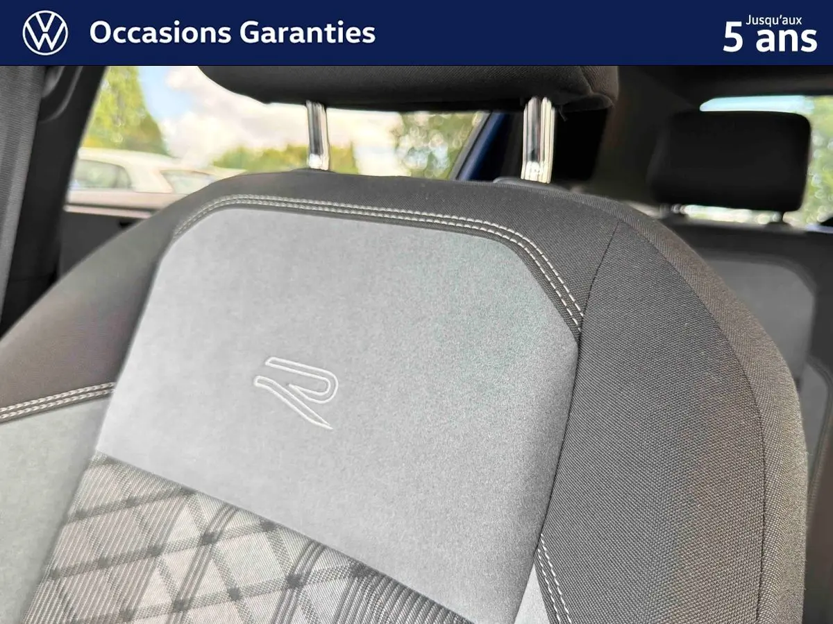 Détail du siège avant gris avec logo R brodé, sur Volkswagen Polo 2025, intérieur visible en arrière-plan.