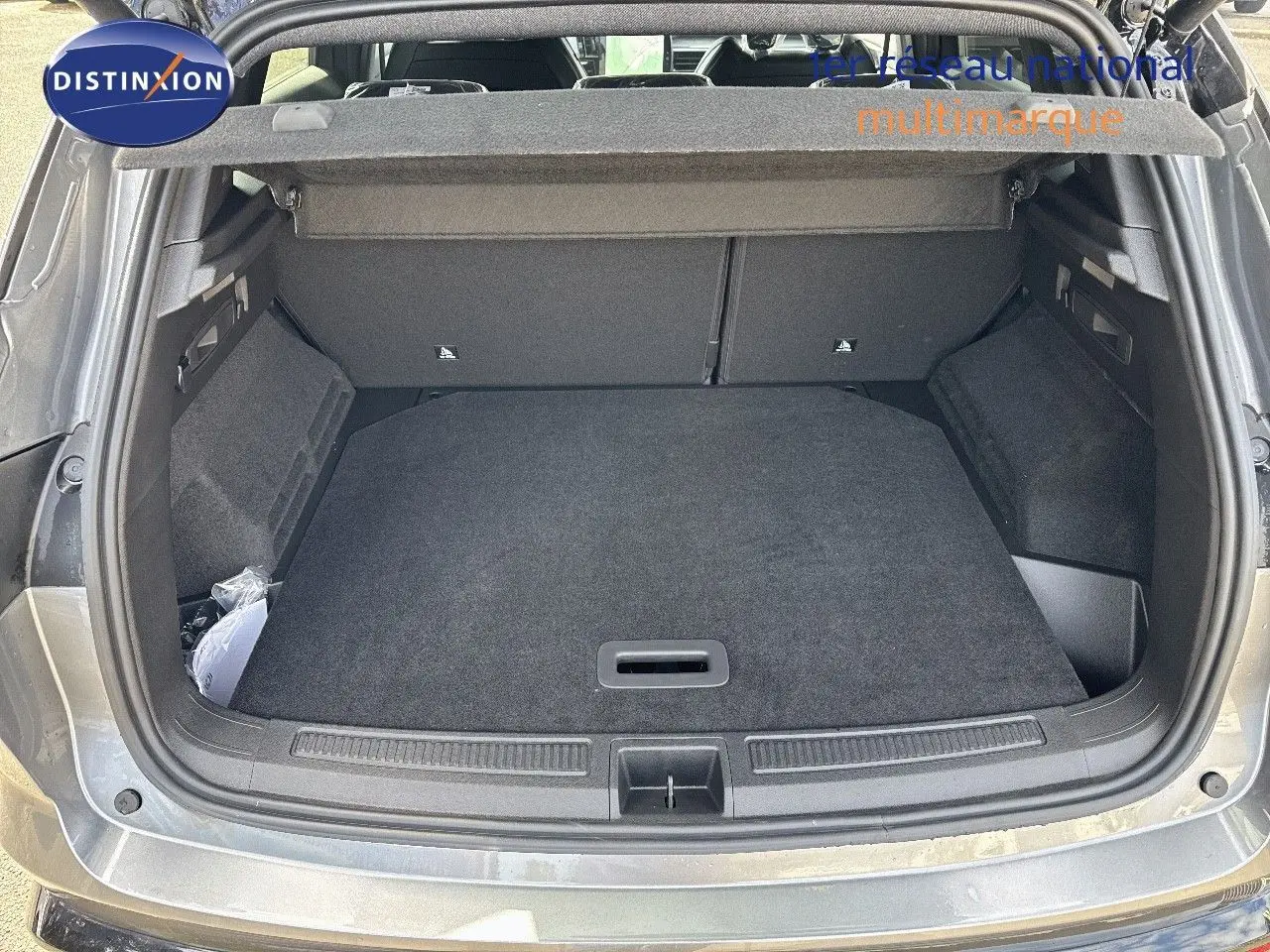 Coffre ouvert vu de l'arrière d'un Renault Austral gris schiste métal avec toit noir, montrant l'espace de chargement vide.