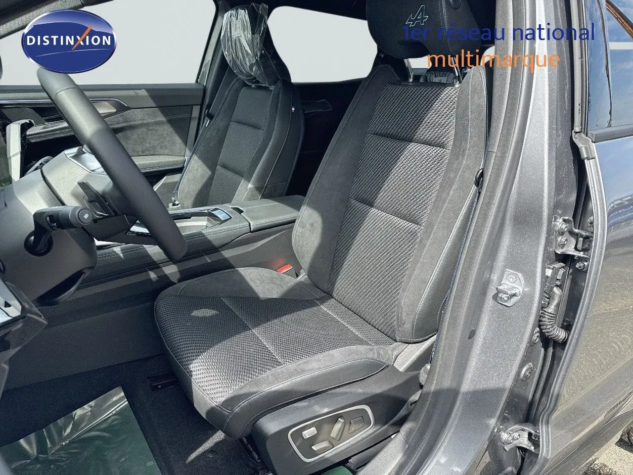 Vue intérieure côté conducteur du Renault Austral gris schiste avec sièges en tissu et cuir noir, volant multifonction et détails modernes.