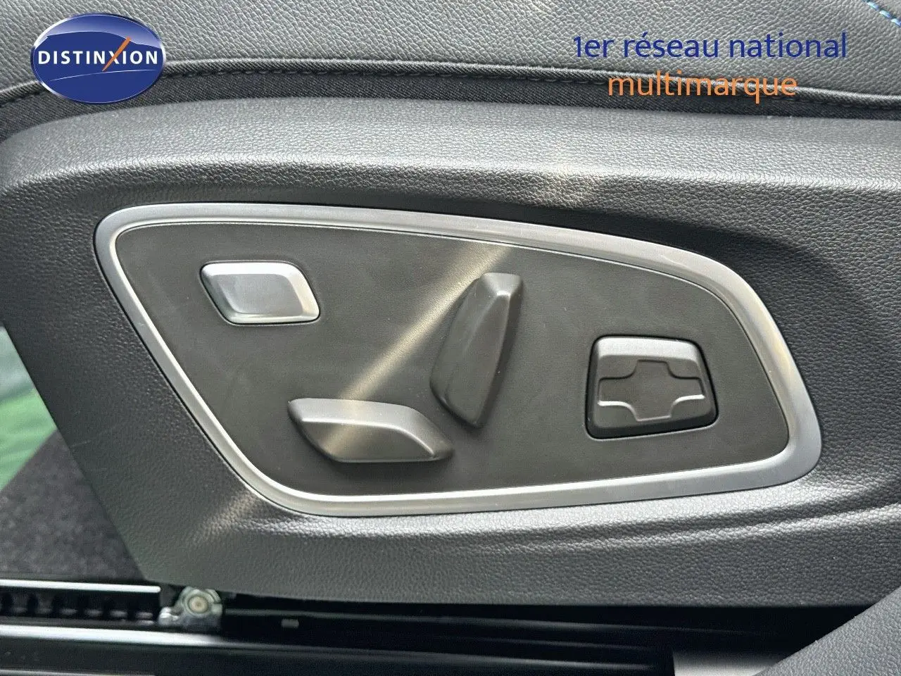 Commandes électriques des réglages de siège sur la porte côté gauche d’un Renault Austral gris schiste métal avec toit noir.
