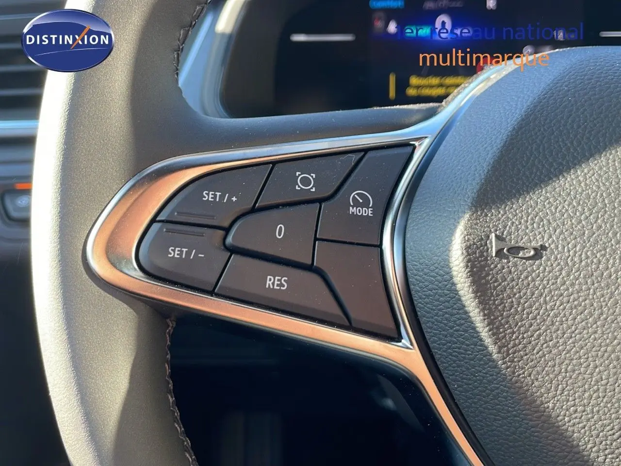 Gros plan sur les commandes de régulateur au volant du Renault Captur E-Tech gris rafale métal avec affichage numérique en arrière-plan.