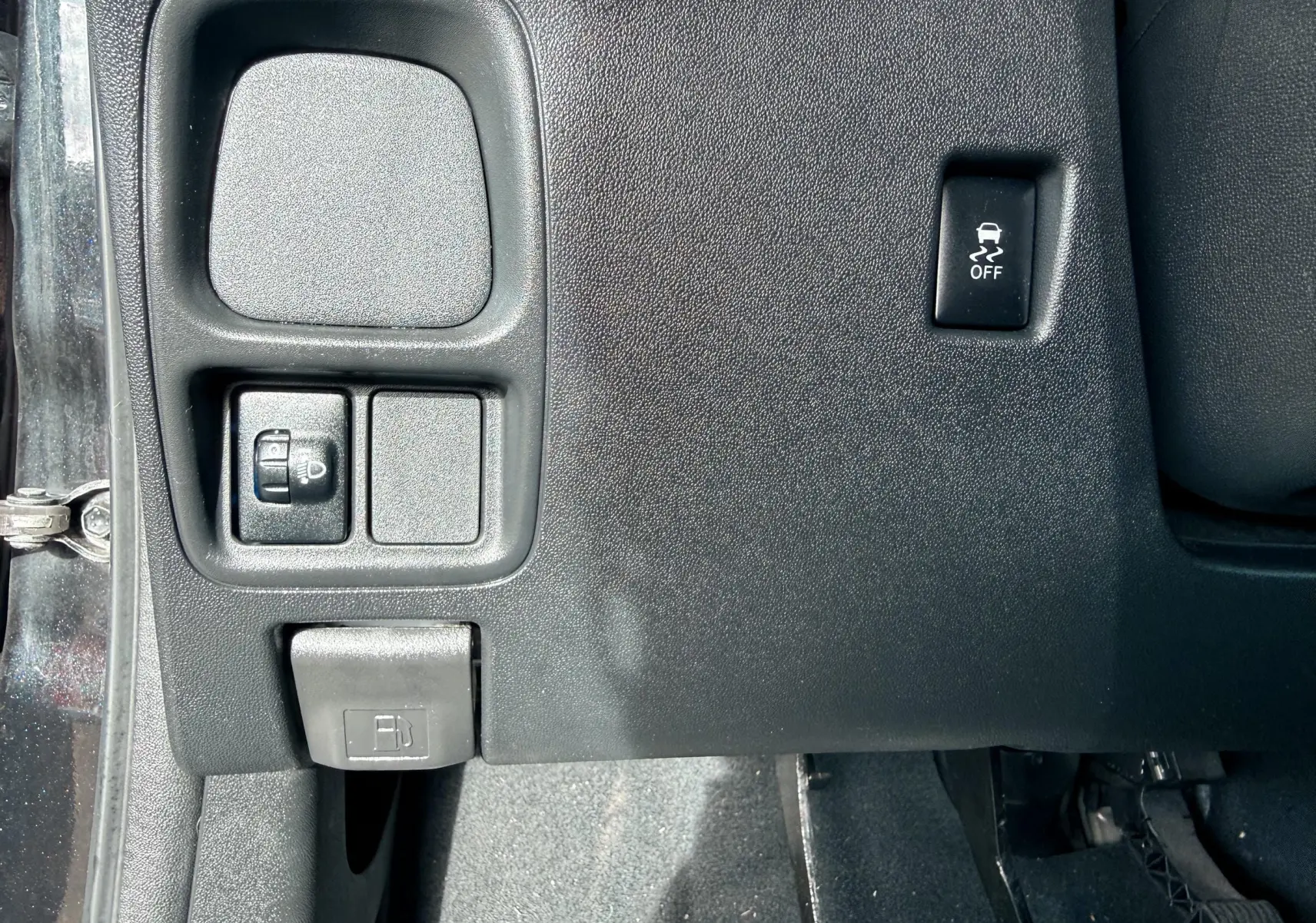 Détail du tableau de bord côté gauche d'une Peugeot 108 noire, montrant les commandes d'éclairage et le bouton de désactivation de l'ESP.