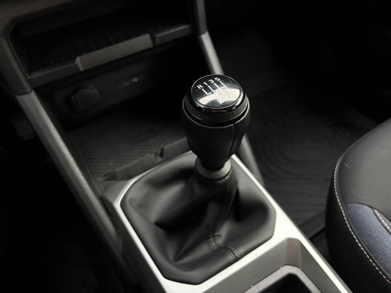 Le levier de vitesses manuel noir du Dacia Duster 2024, vue rapprochée de la console centrale intérieure.