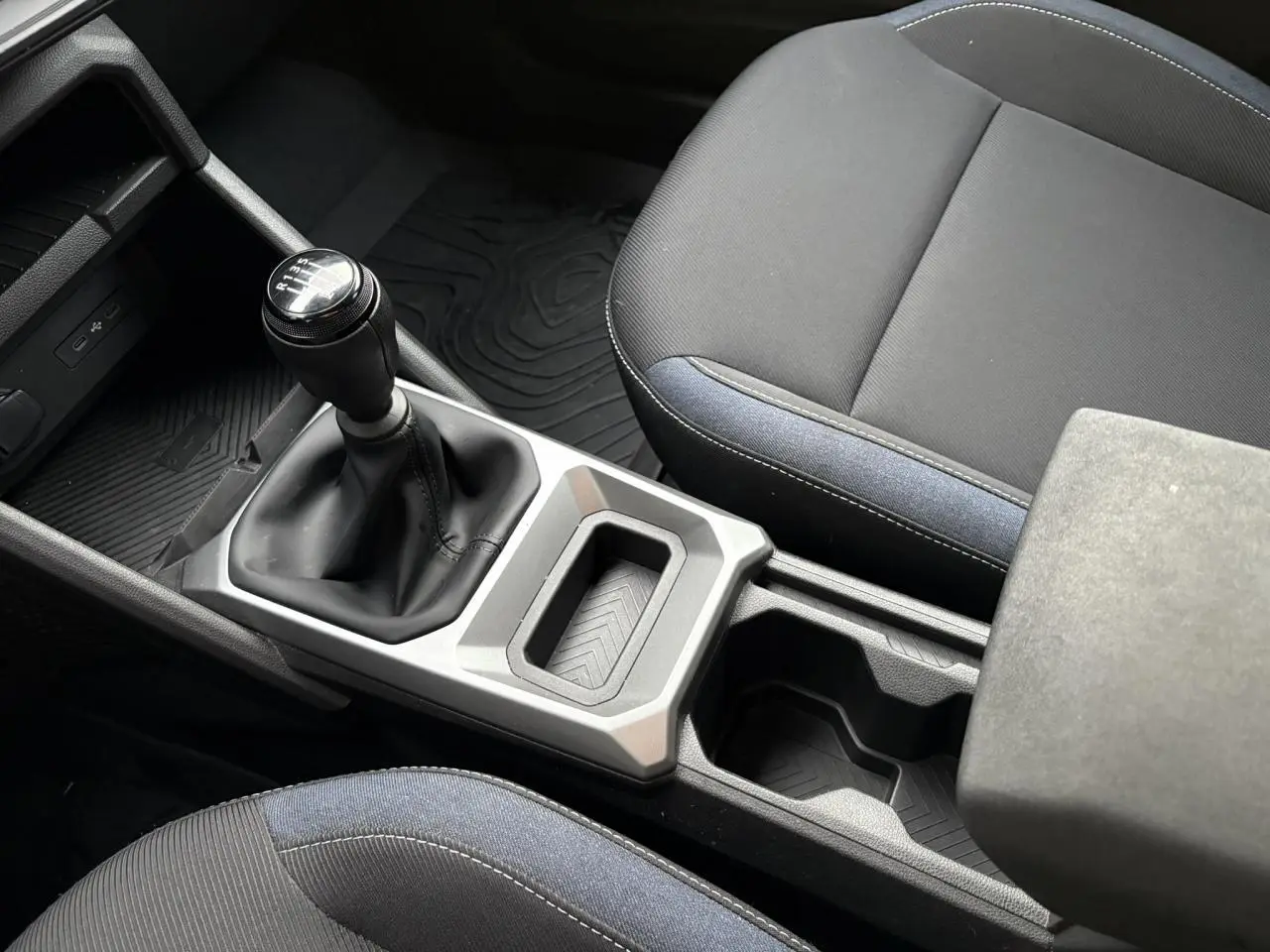 Vue rapprochée de la console centrale et levier de vitesses manuel du Dacia Duster 2024 avec sellerie Denim bleu et noire.