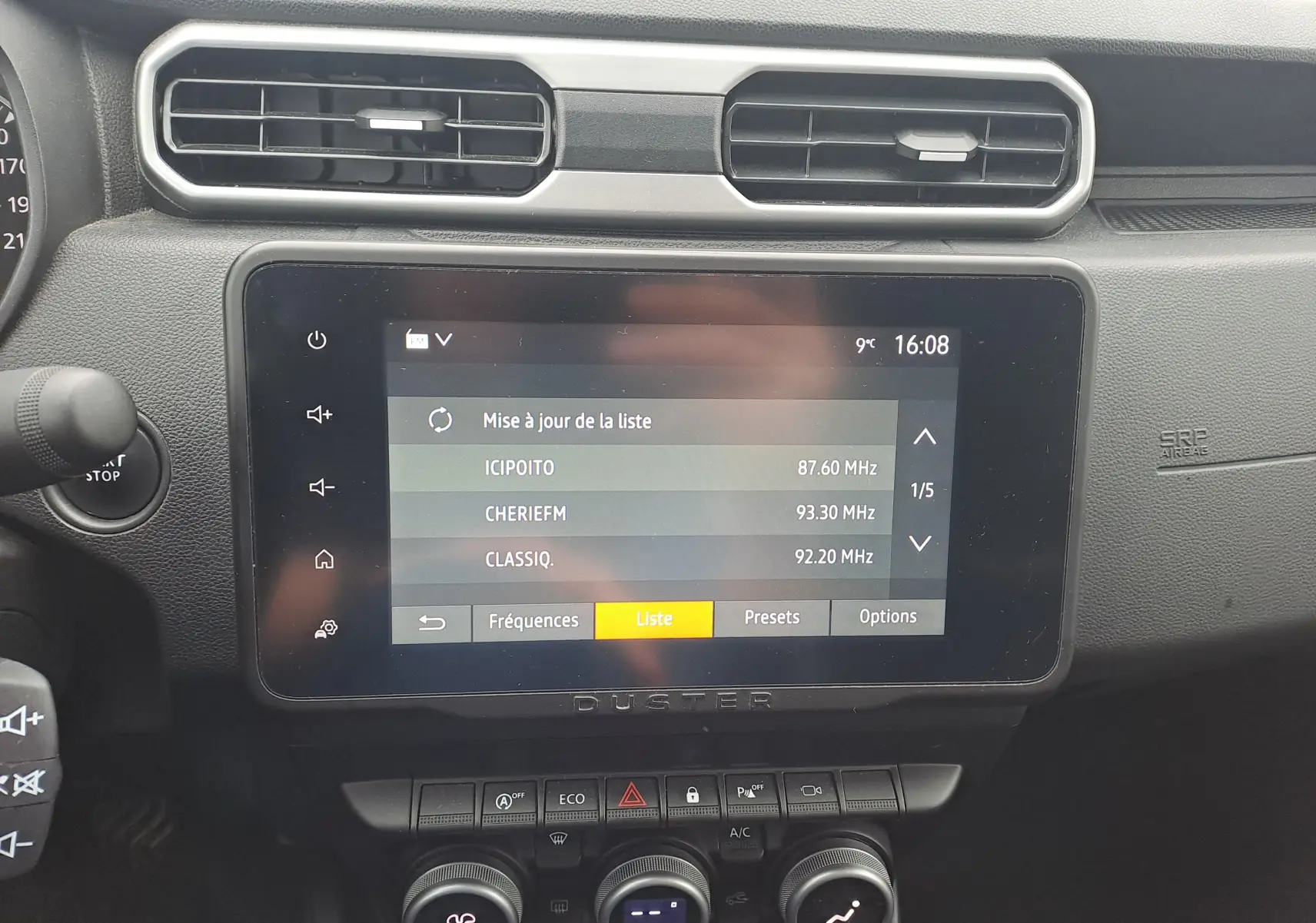 Vue rapprochée de l’écran tactile central et des commandes de climatisation du Dacia Duster 2023, intérieur noir.