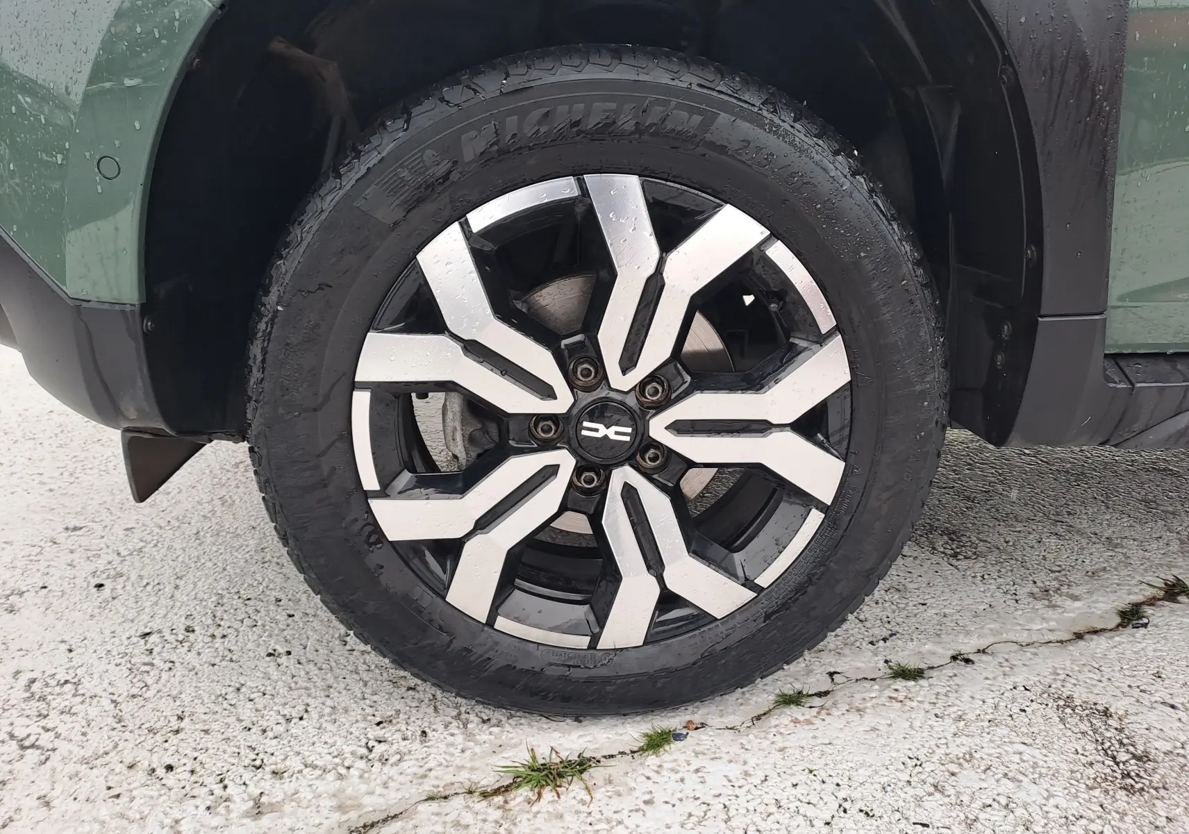 Gros plan sur la roue avant gauche du Dacia Duster kaki Liken 2023 avec jante alliage bicolore au design moderne.