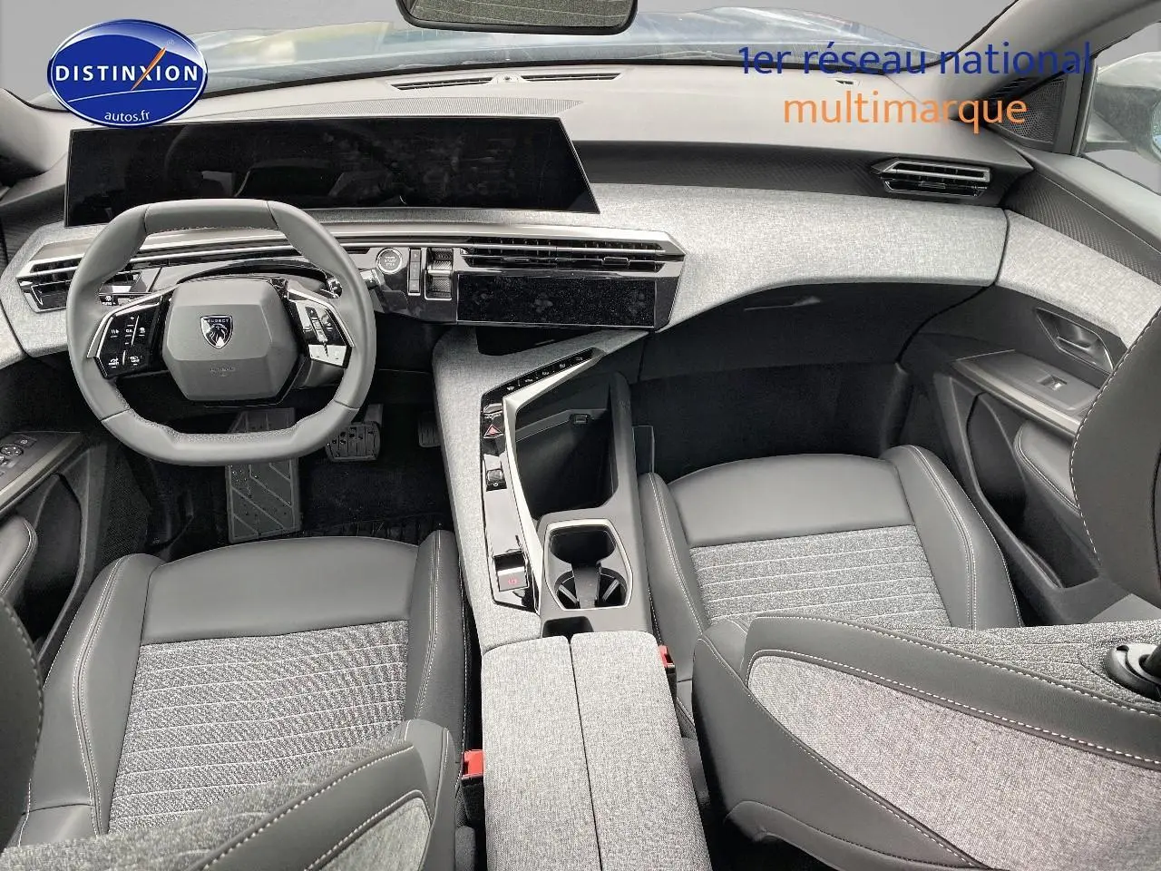 Vue intérieure avant du Peugeot 3008 2025, tableau de bord et sièges en cuir et tissu gris avec volant multifonction.