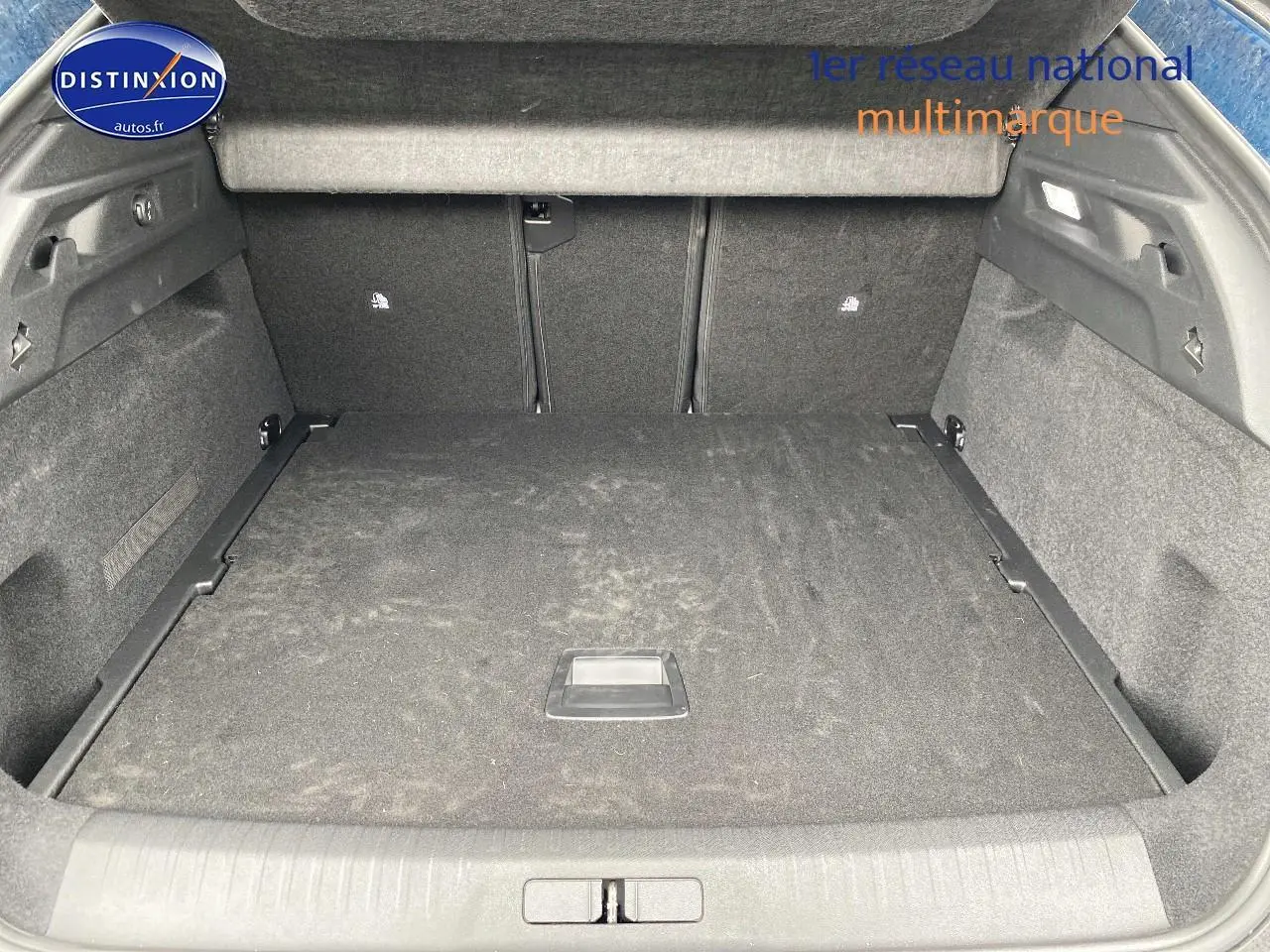 Coffre spacieux vu de l'arrière d'un Peugeot 3008 bleu 2025, avec plancher de coffre plat et habillage gris.