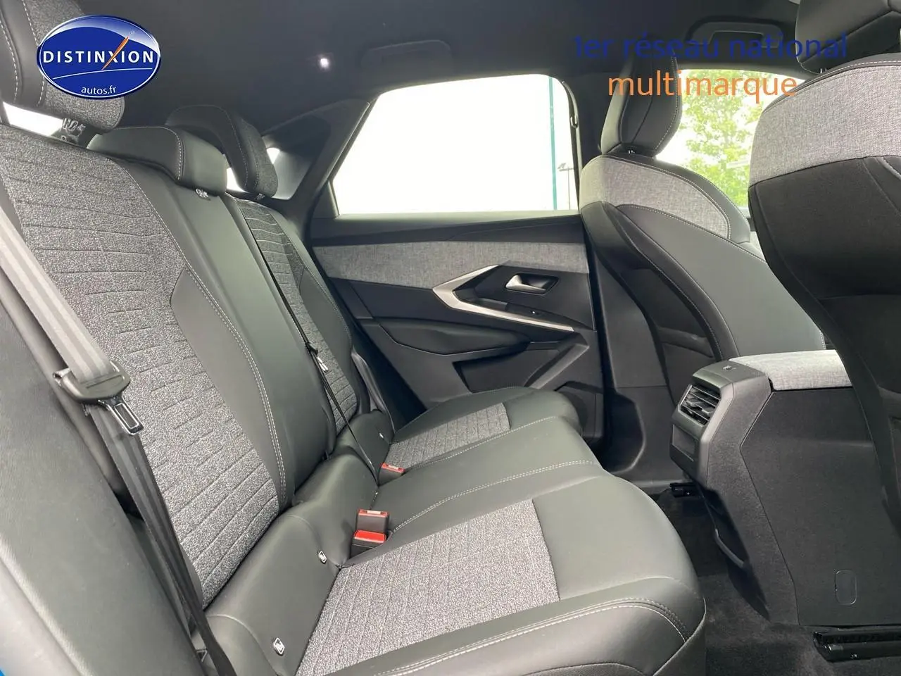 Vue latérale droite de l'intérieur arrière du Peugeot 3008 2025 avec sièges bi-matière gris et noir.