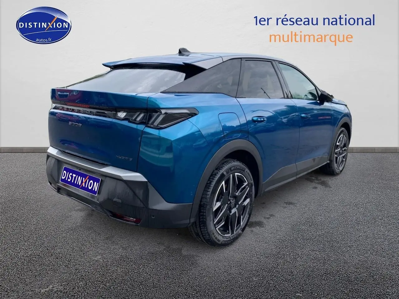 Vue 3/4 arrière droite d’un Peugeot 3008 hybride bleu 2025 avec jantes alu et becquet arrière.