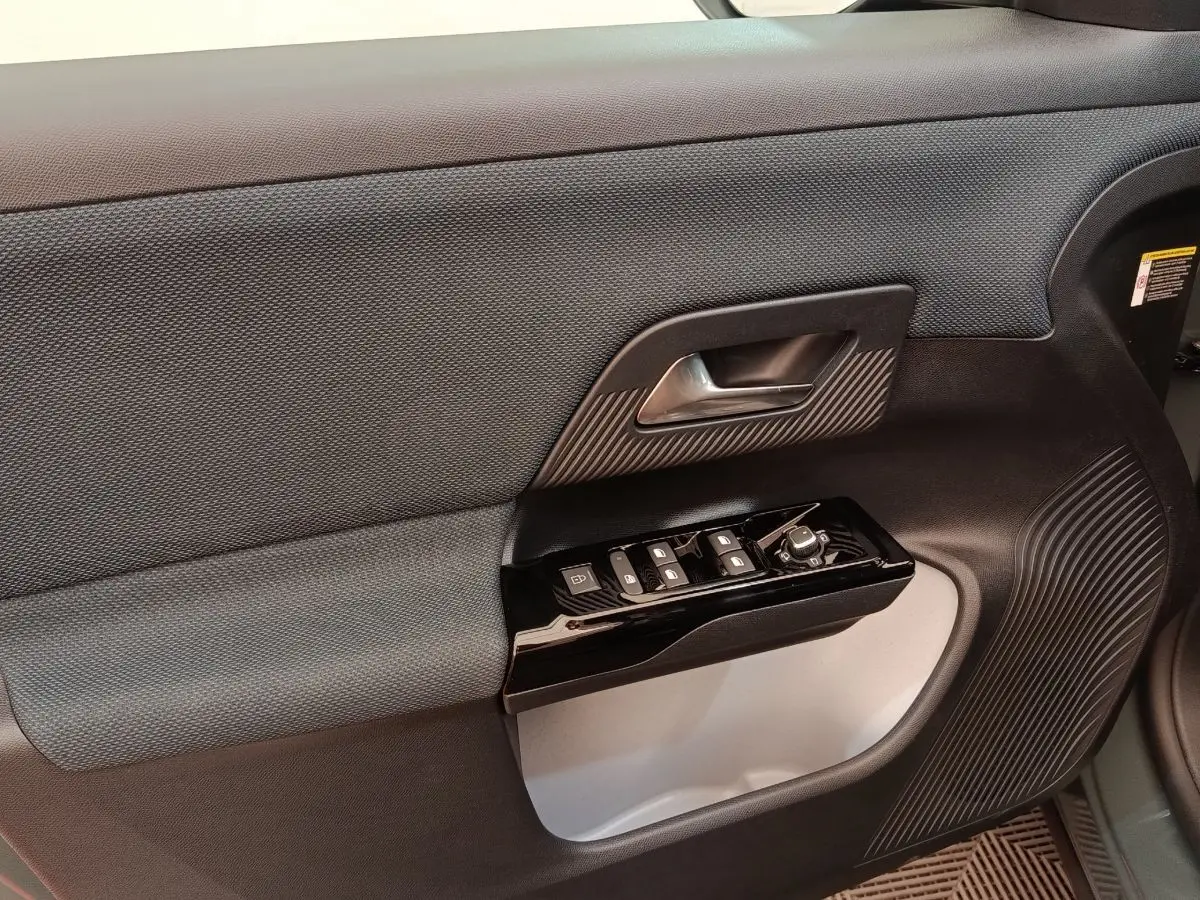 Détail de la porte intérieure côté conducteur de la Citroën C5 hybride 2026 avec commandes de vitres et poignée noire.