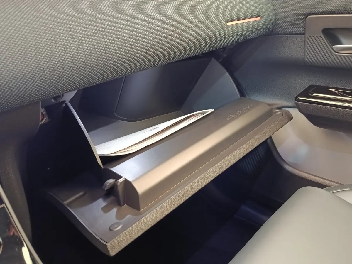 Gant de boîte à gants ouvert côté passager avec intérieur noir et document partiellement visible dans une Citroën C5 Hybride.