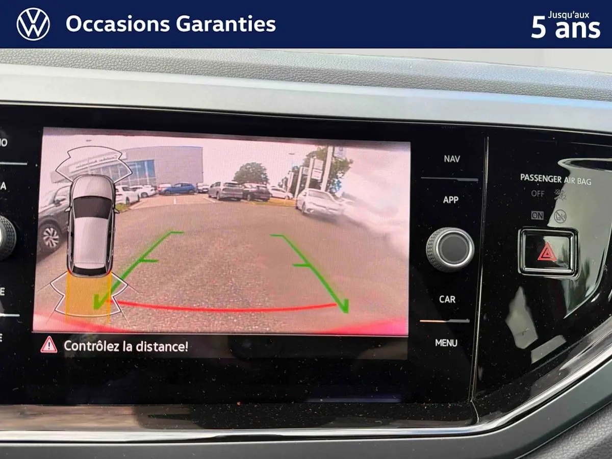 Écran tactile de la Volkswagen Polo rouge montrant la caméra de recul avec guidage dynamique en vue arrière.