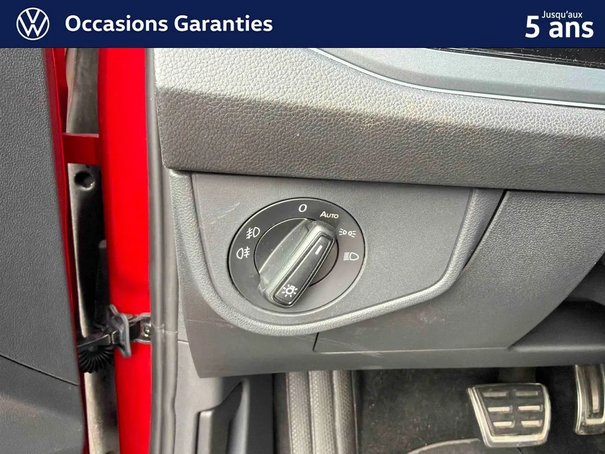 Détail de la commande d’éclairage sur le tableau de bord côté gauche d’une Volkswagen Polo rouge 2025.