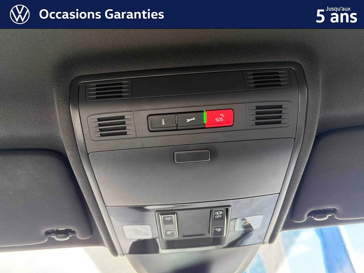 Vue intérieure en gros plan du plafonnier avec commandes d’éclairage et bouton SOS de la Volkswagen Polo rouge 2025.