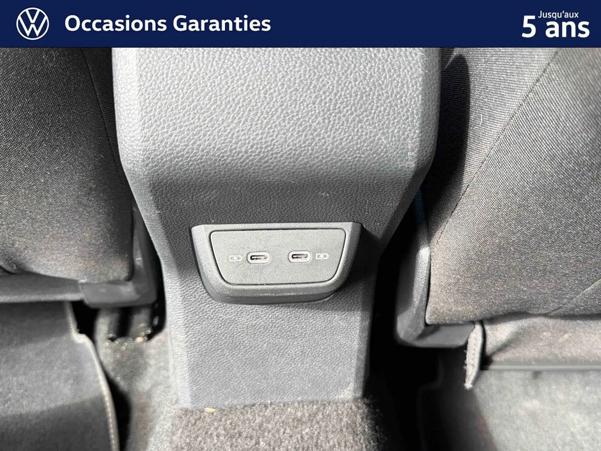 Prise USB-C double en bas de la console centrale entre les sièges arrière d'une Volkswagen Polo rouge 2025.
