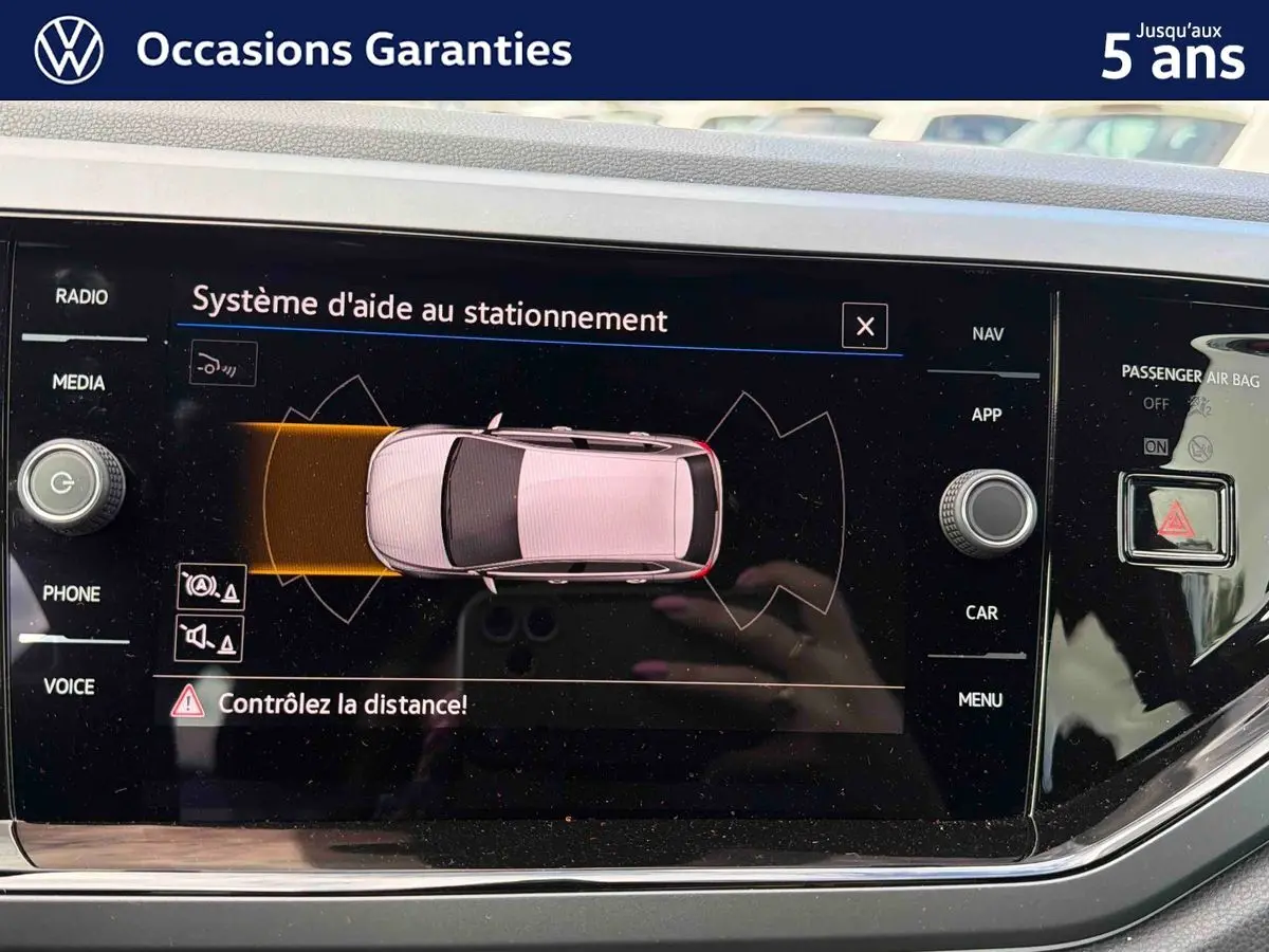 Écran tactile intérieur affichant le système d'aide au stationnement de la Volkswagen Polo 2025 en vue de dessus du véhicule.