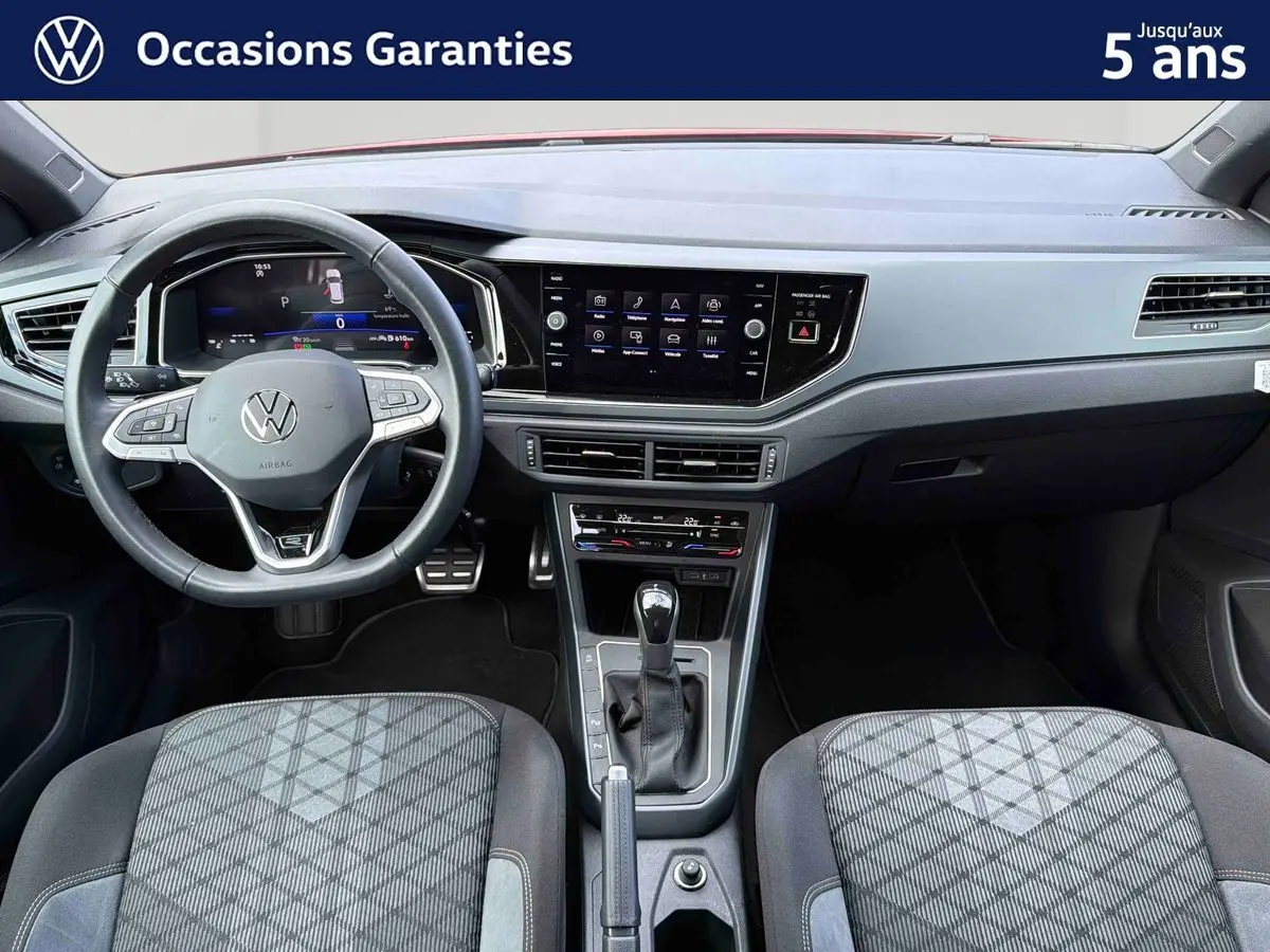 Vue intérieure avant du tableau de bord et volant cuir multifonctions d'une Volkswagen Polo 2025 avec levier de vitesse et écran tactile central.