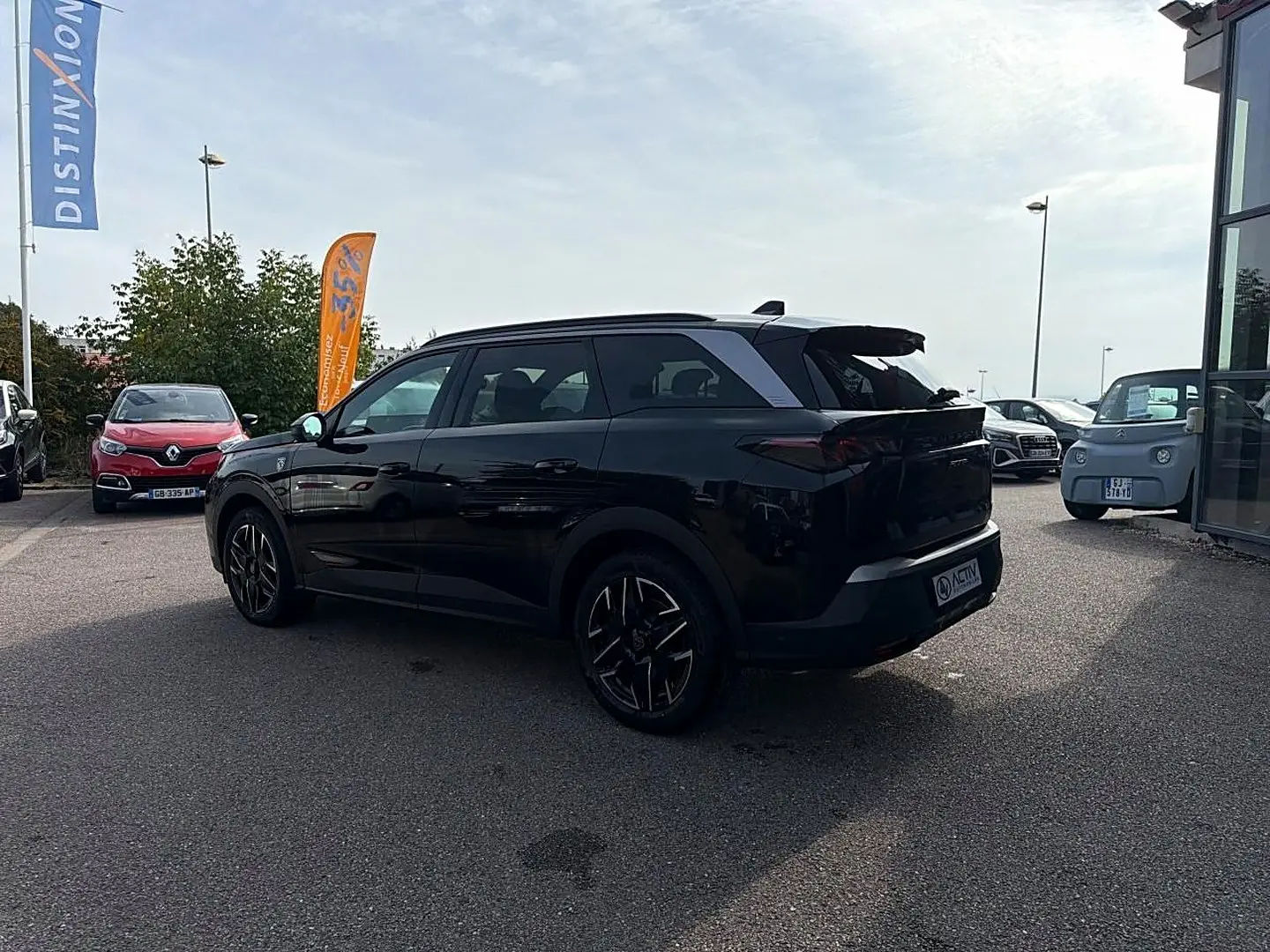 Peugeot 5008 Hybrid noir vue 3/4 arrière droit, jantes alu noires et toit contrasté gris.