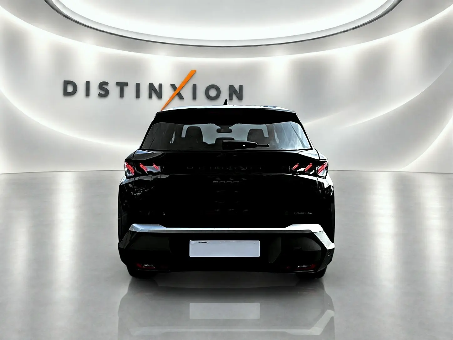 Vue arrière d'un Peugeot 5008 Hybrid 145 GT noir, avec feux arrière LED et becquet distinctif dans un showroom lumineux.