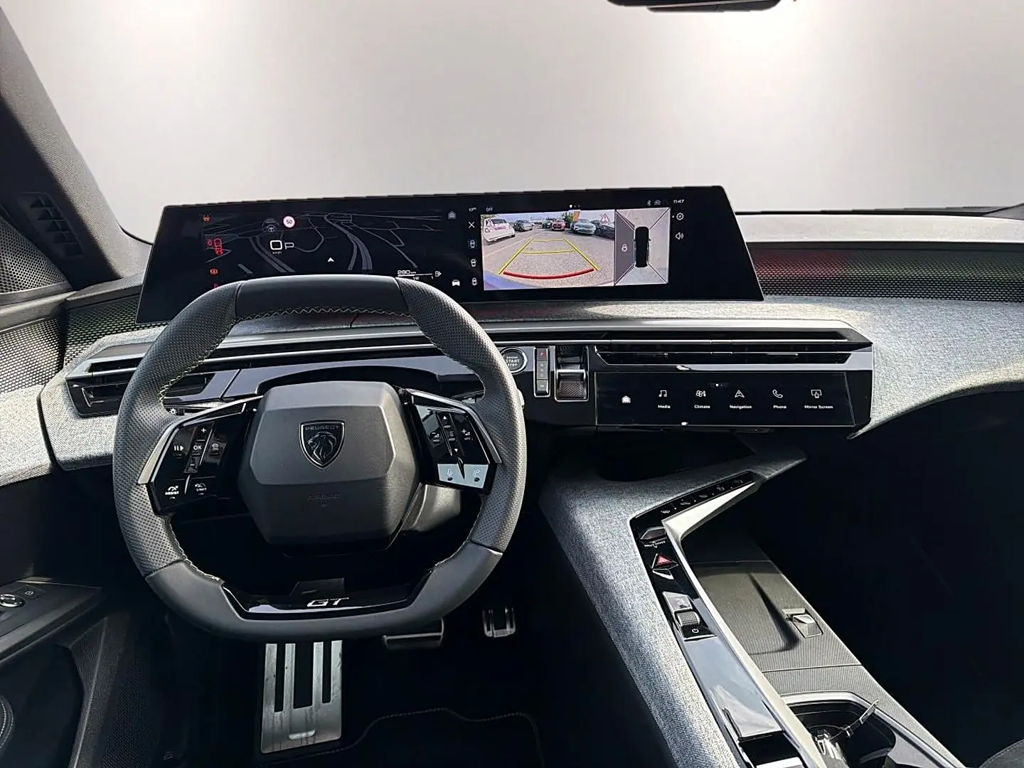 Vue intérieure du tableau de bord du Peugeot 5008 Hybrid 145 GT, avec volant cuir multifonction et écran tactile panoramique.