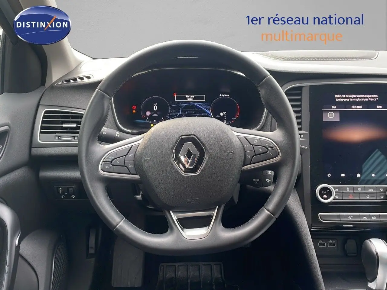 Vue intérieure centrée sur le volant et le tableau de bord numérique de la Renault Mégane Break 2024 gris Highland Metal.