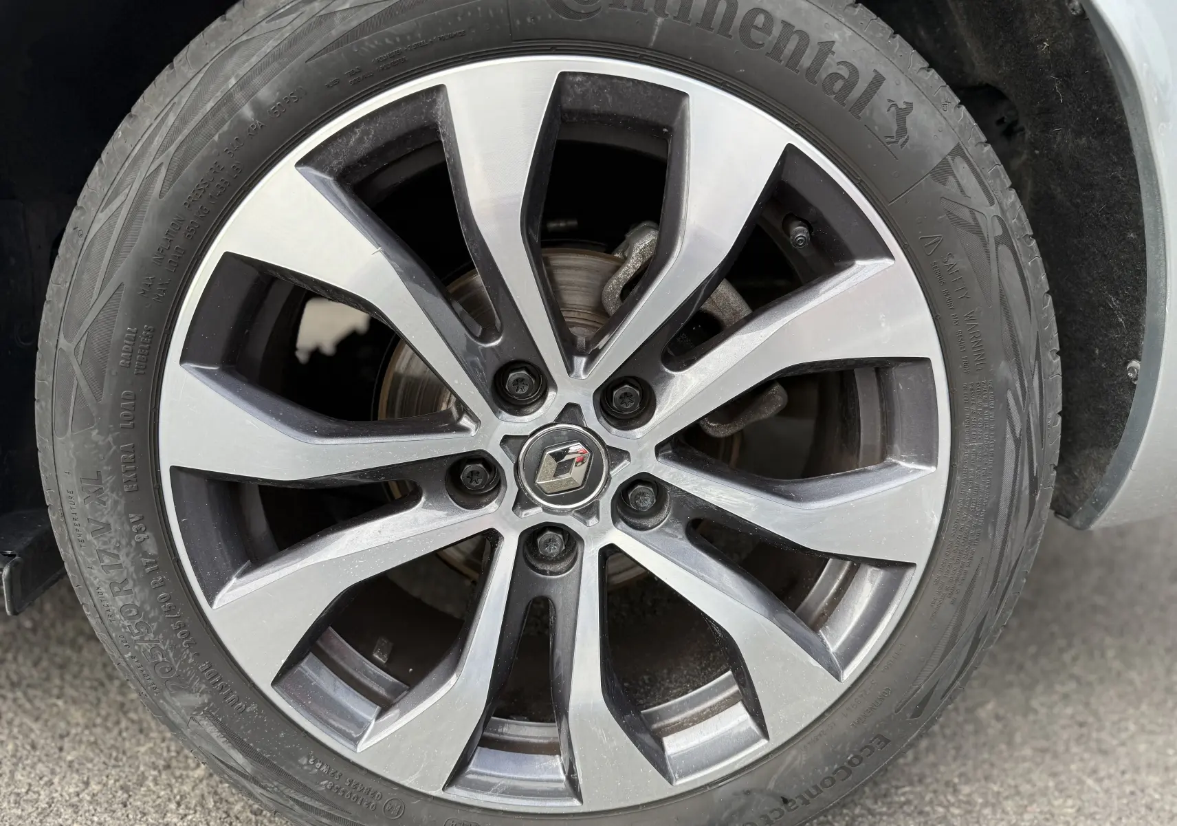 Gros plan sur la jante alliage bicolore de la Renault Mégane Break gris Highland Metal 2024, avec logo central Renault.