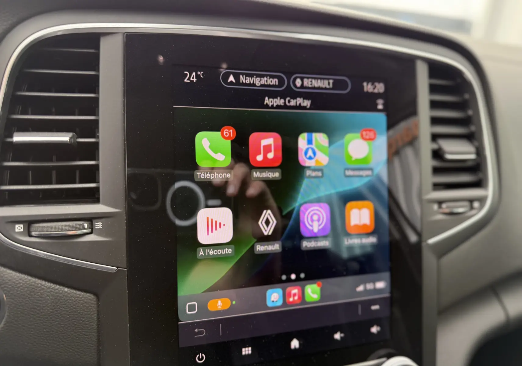 Écran tactile central de la Renault Mégane Break 2024 affichant Apple CarPlay avec commandes climatisation visibles.