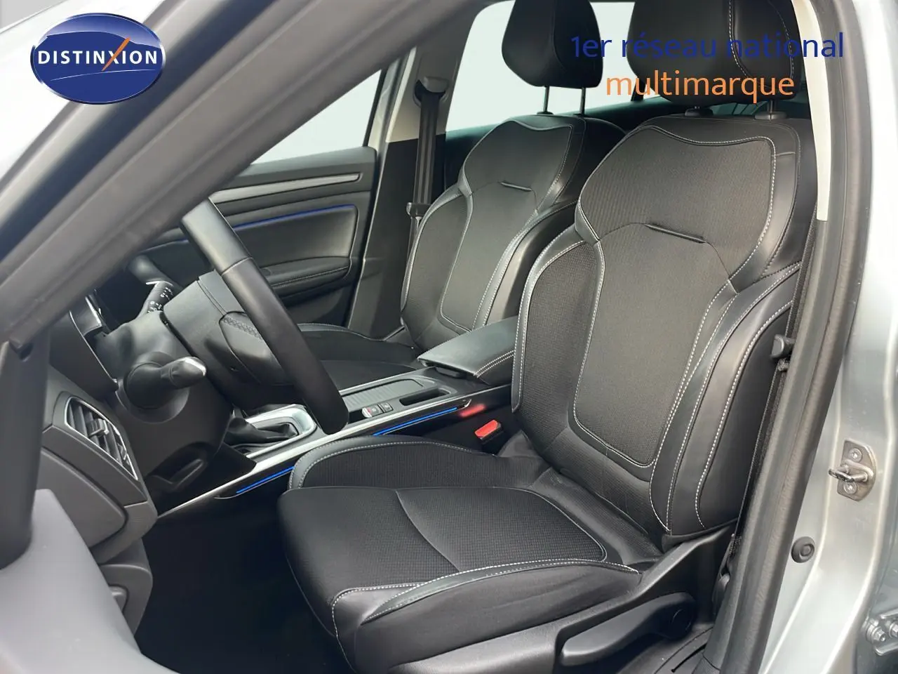 Intérieur de la Renault Mégane Break 2024 en gris Highland Metal, vue côté conducteur sur les sièges noirs en cuir et tissu.