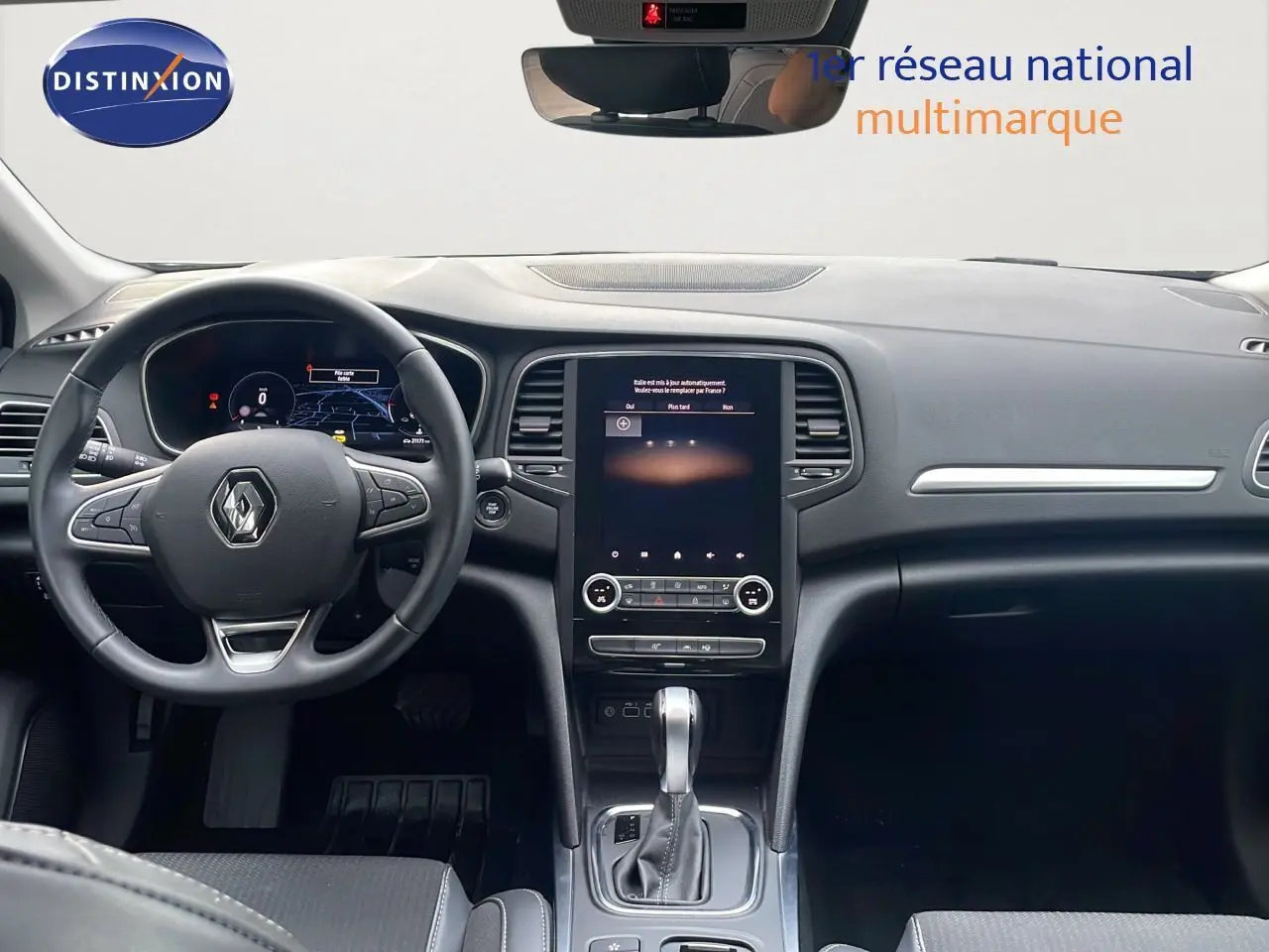 Vue intérieure du poste de conduite de la Renault Mégane Break 2024, avec volant multifonction et écran tactile central.