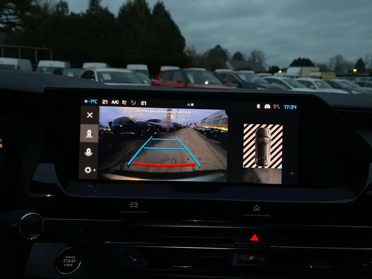 Vue de l'écran intérieur montrant la caméra de recul active d'une Citroën C5 X gris Artense métal en stationnement.